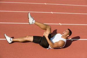 Injured runner lying on running track